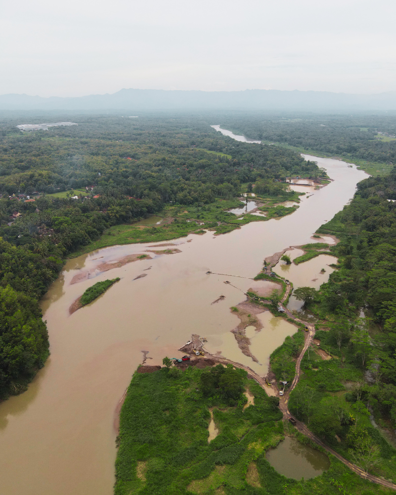 Airborne image of a river running through forested areas with structures